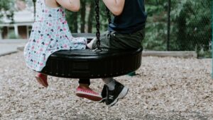 Twee kinderen spelen samen op een schommel gemaakt van een autoband