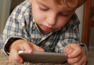 Kleine jongen kijkt op zijn smartphone