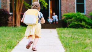 Jong meisje met rugzak onderweg naar school