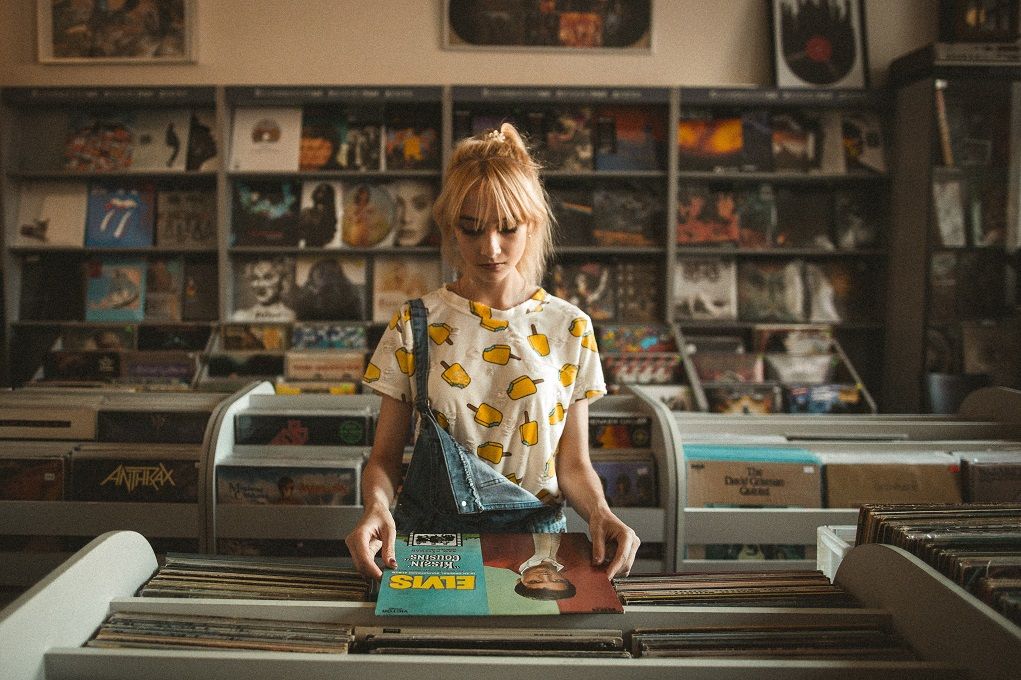 Vrouw in platenzaak kijkt naar vinyl plaat